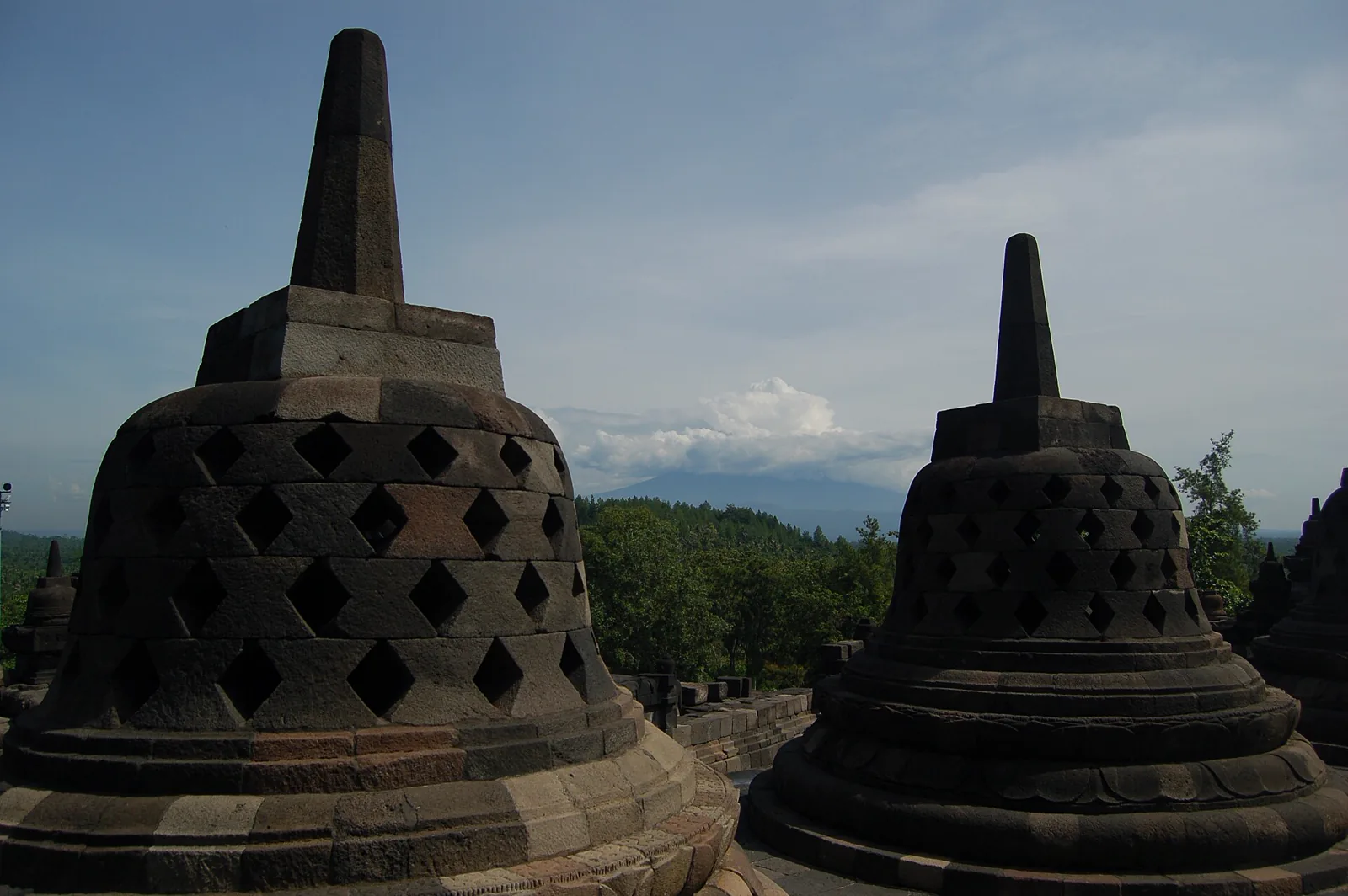Stupas at Borobudur with a mountain landscape beyond
