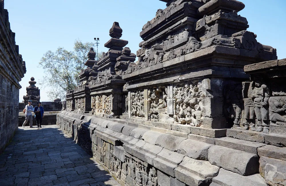 A carved stone corridor of narrative relief panels at Borobudur