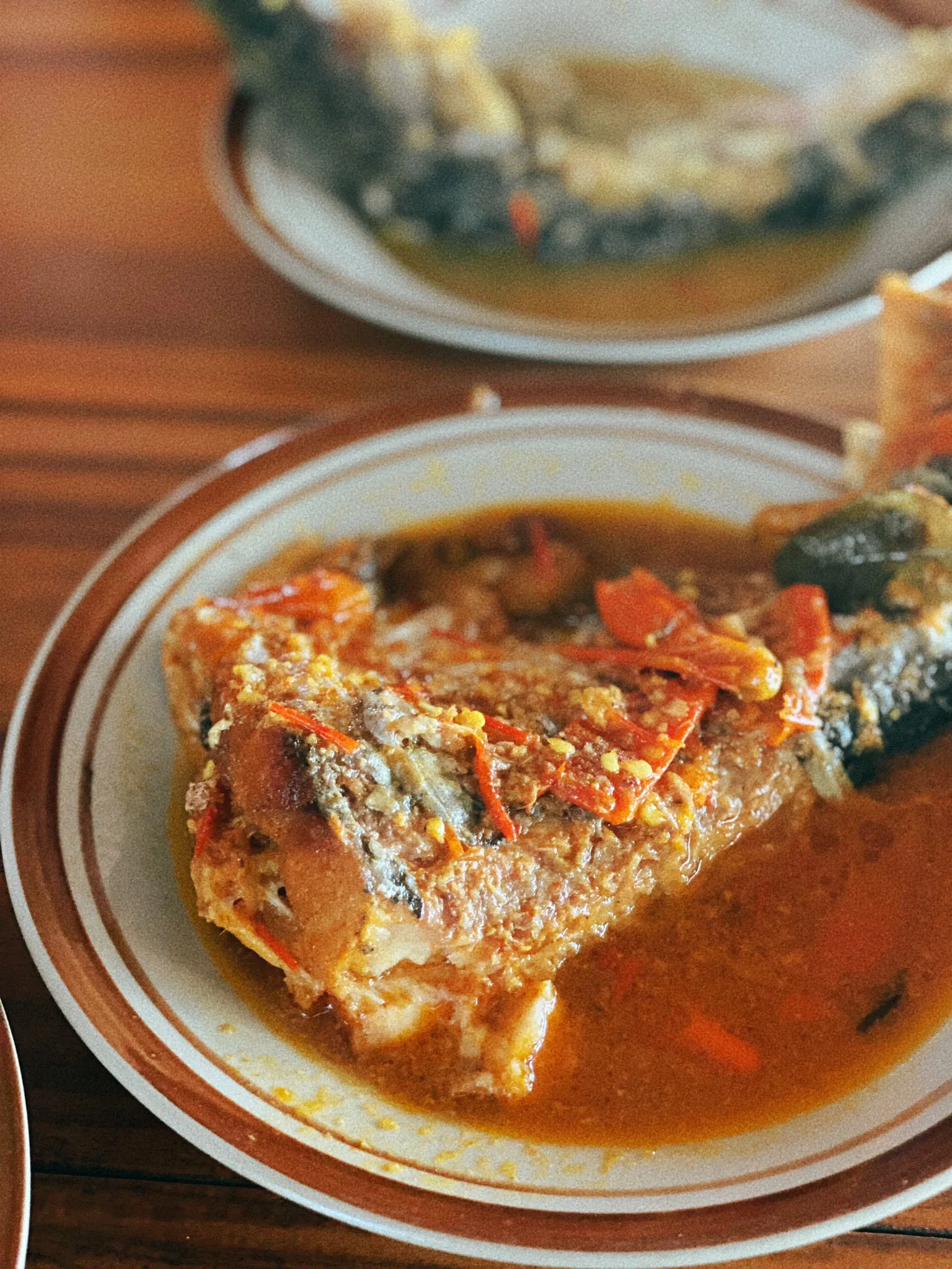 A plate of Mangut Beong with fish in a spiced coconut-milk sauce