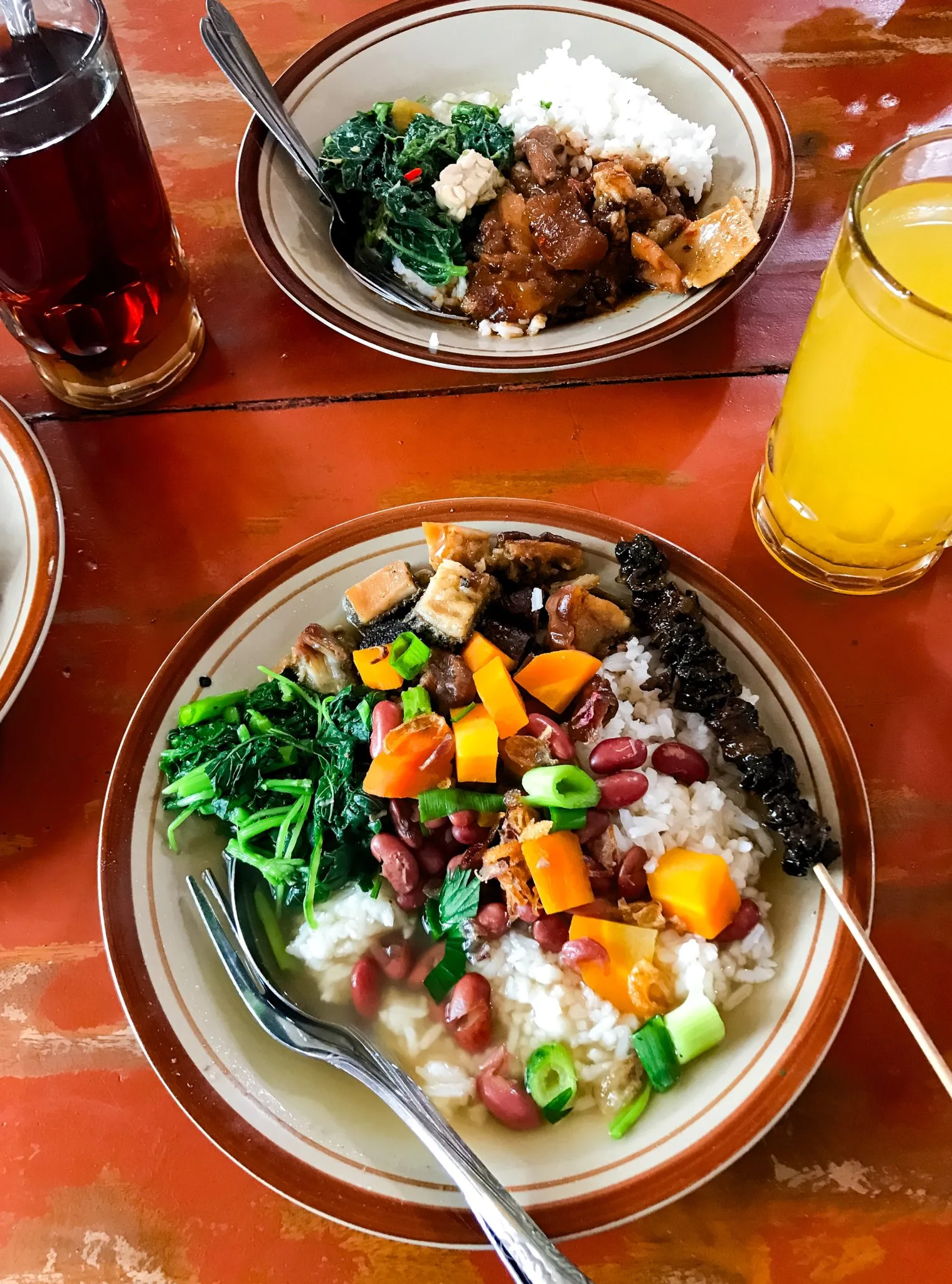 Two bowls of Sop Senerek set out with a drink beside them